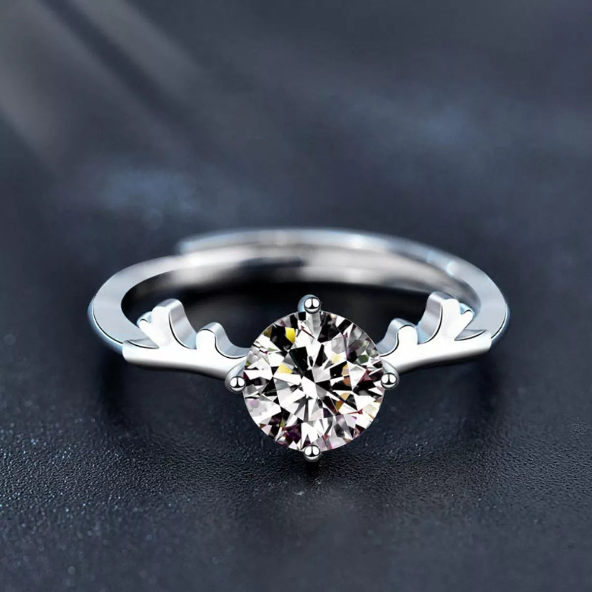 Silver ring with a diamond on a dark background