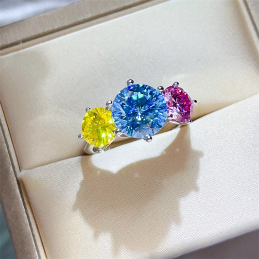 Ring with three colorful gemstones on a beige cushion