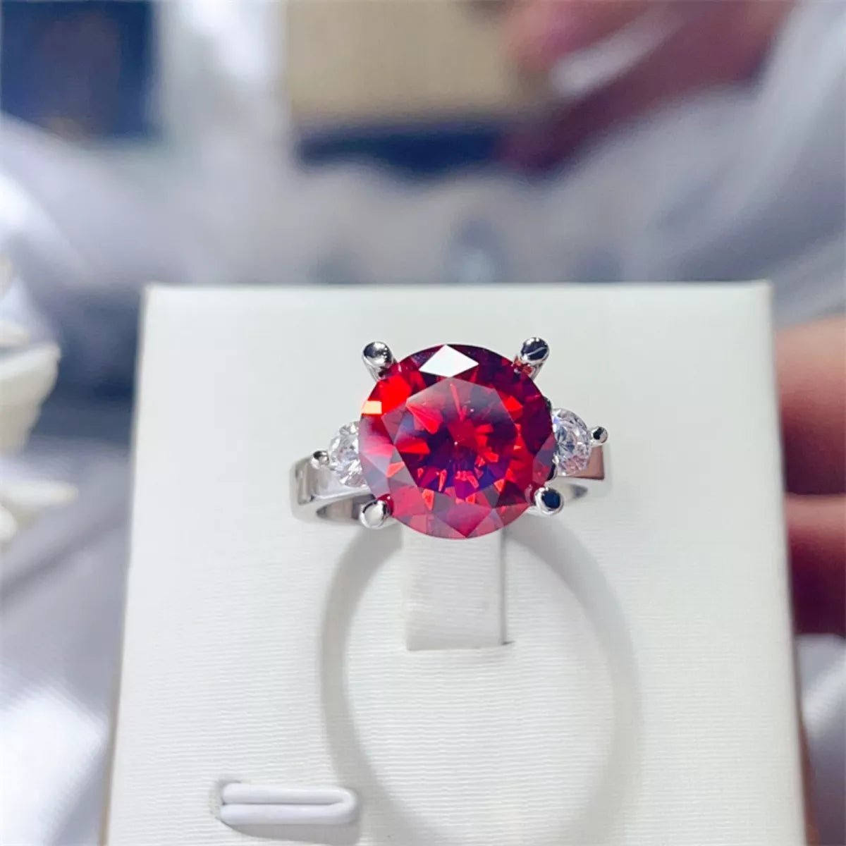 Ring with a red gemstone on a white box