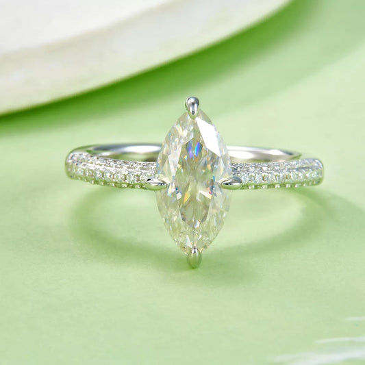 Silver ring with a pear-shaped diamond on a green background